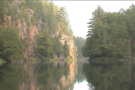 Looking back at the same wall from further upstream... 	With some rare sunlight helping out.